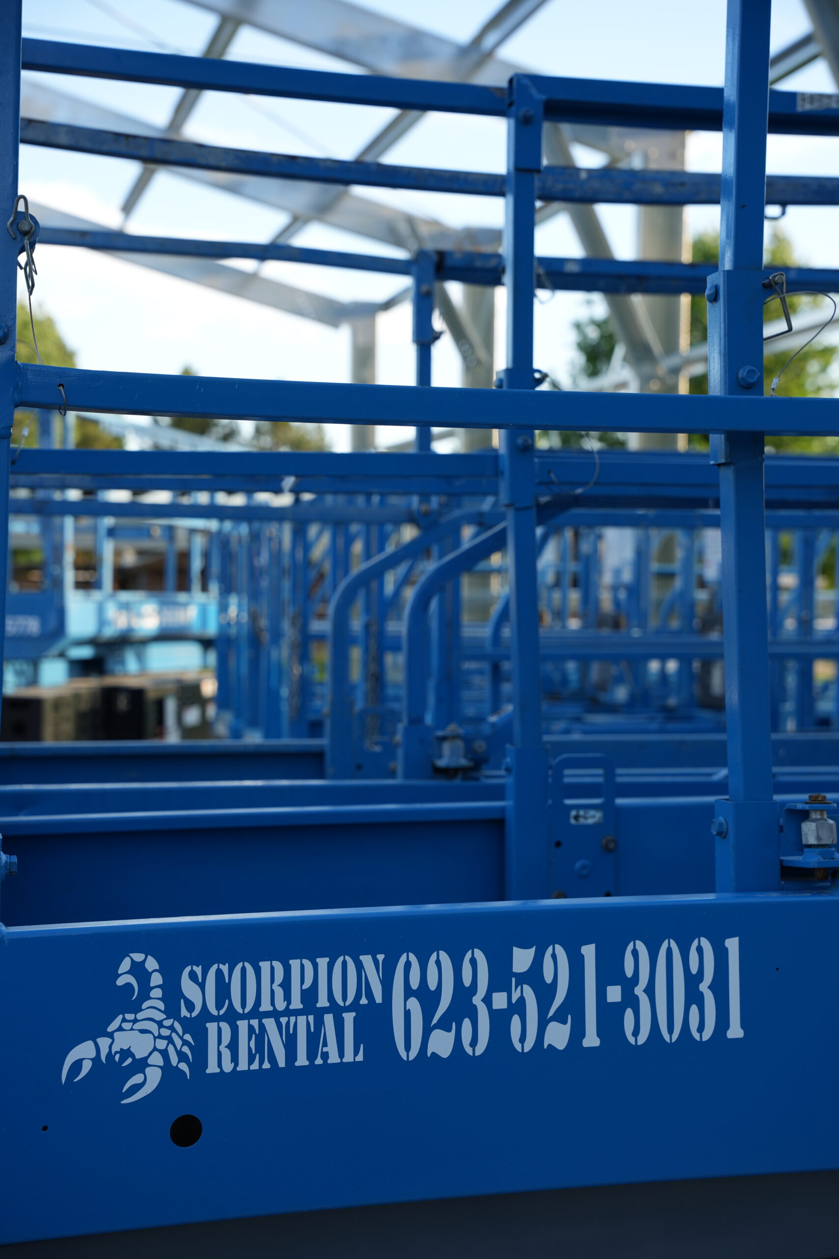 Scorpion Rental on-slab electric scissor lifts Row of Scorpion Rental on-slab electric scissor lifts with logo and phone number
